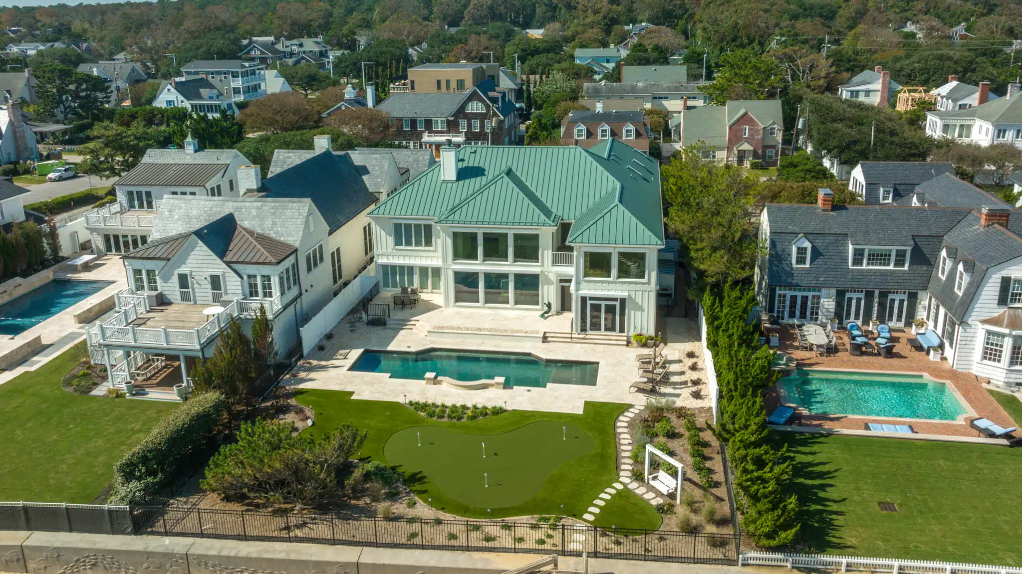 Resort-style backyard with pool, spa, and putting green